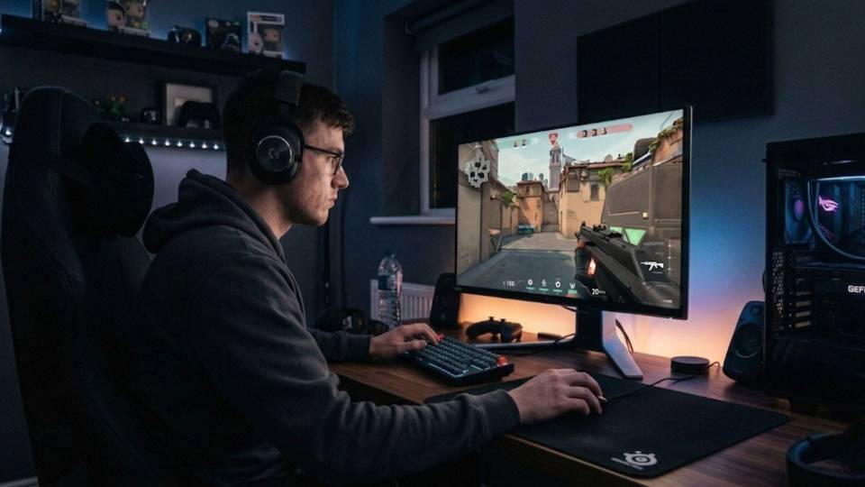 Competitive Valorant player at clean desk setup with 240Hz monitor